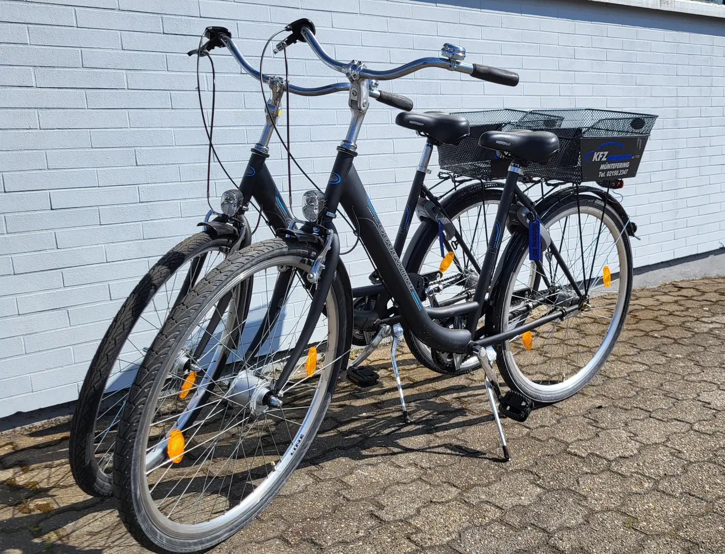 Zwei Fahrräder mit Korb vor dem Werkstattgebäude